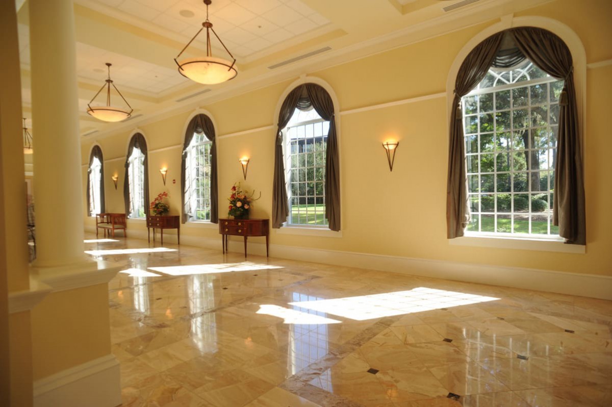 A spacious and elegant hall with large arched windows allowing sunlight to flood the room.