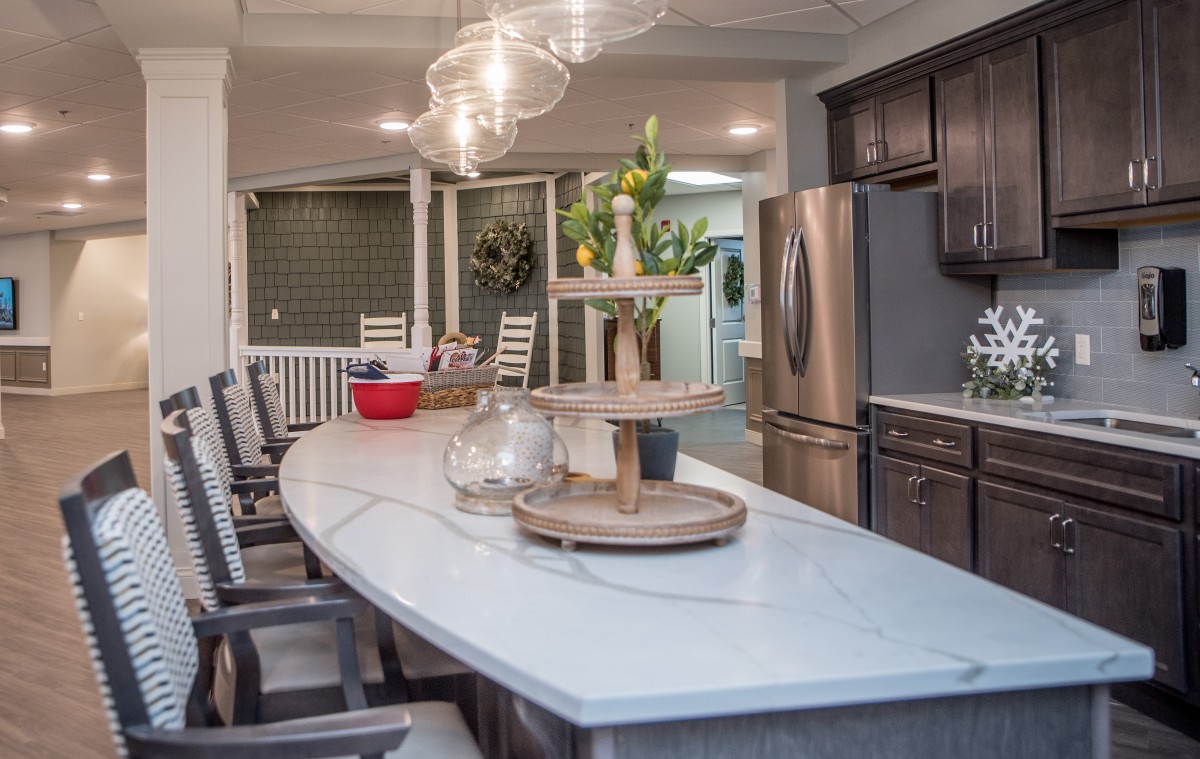 A modern kitchen interior featuring a spacious island with a sleek countertop, stainless steel appliances, and elegant pendant lighting.