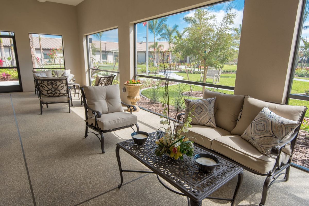 A comfortable patio area with elegant furniture overlooking a lush garden.