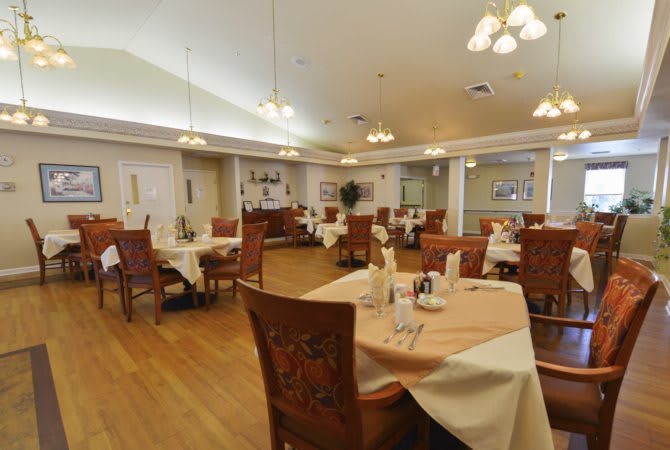 A spacious dining room with elegantly set tables and warm lighting.