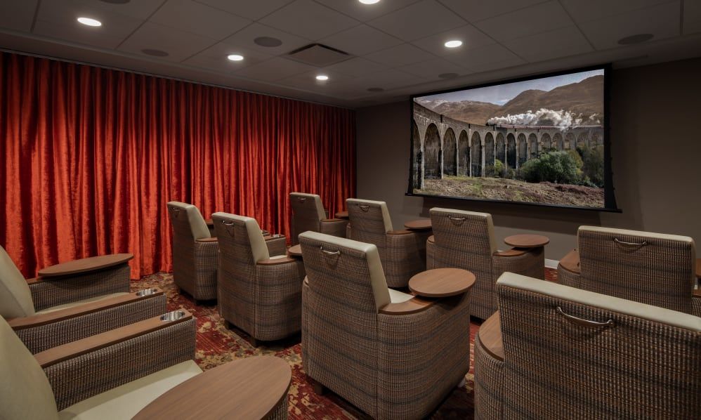 A cozy home theater room with comfortable seating and a large screen.