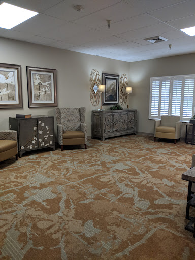 A cozy waiting area featuring comfortable seating, decorative artwork, and elegant furnishings.
