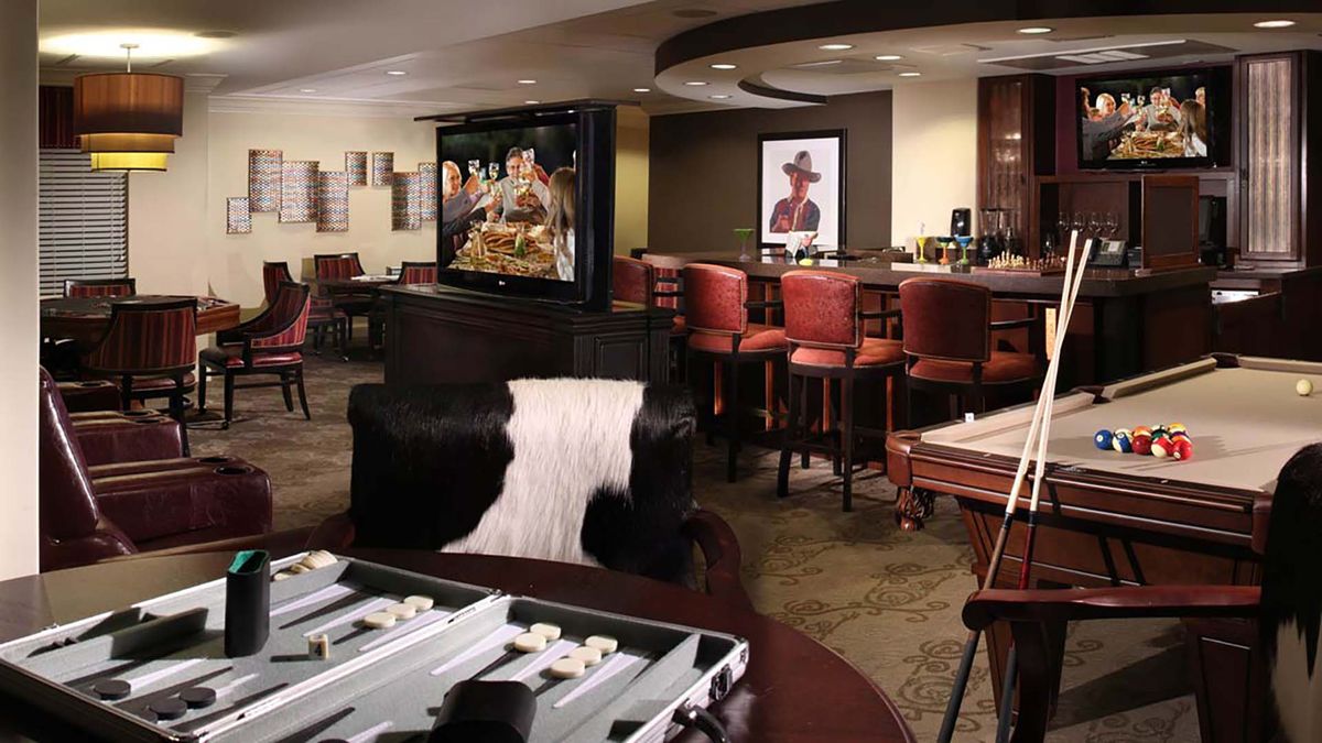 A comfortable lounge and bar area featuring a TV, seating, and a backgammon game setup.
