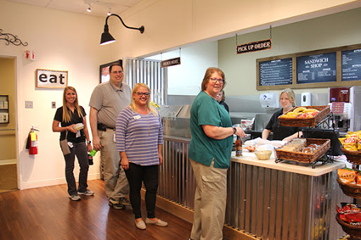 A group of people waiting in line at a cafe, ready to be served.