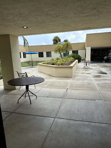 A serene outdoor courtyard featuring a small table and surrounding greenery.