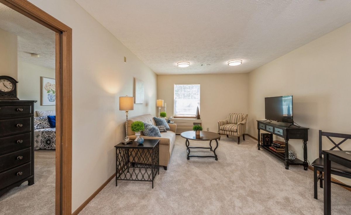 A cozy living room featuring a sofa, coffee table, and television.
