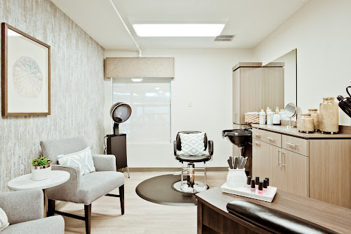 A sleek and modern hair salon interior featuring comfortable seating and elegant design.