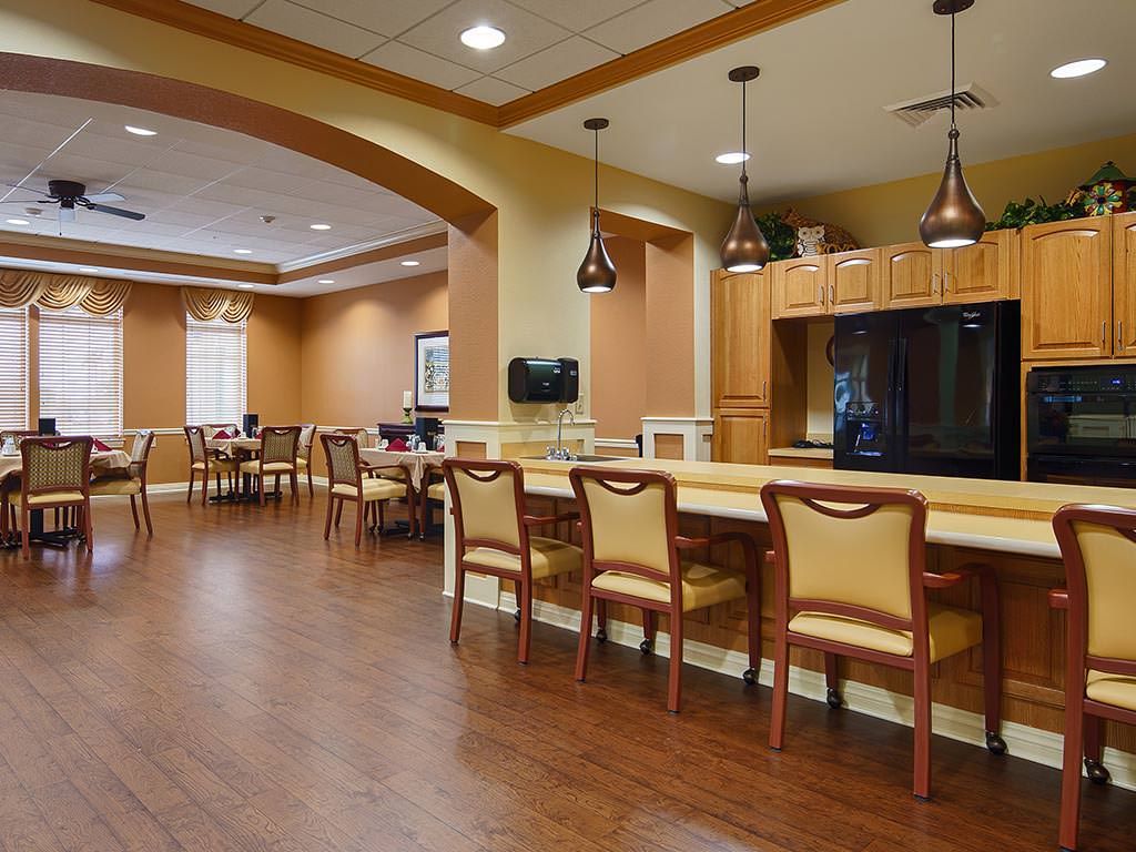 Spacious dining and kitchen area with wooden floors and modern lighting.