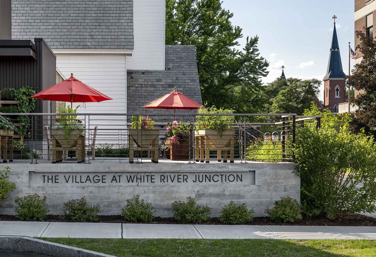 Outdoor patio with red umbrellas at the Village at White River Junction.