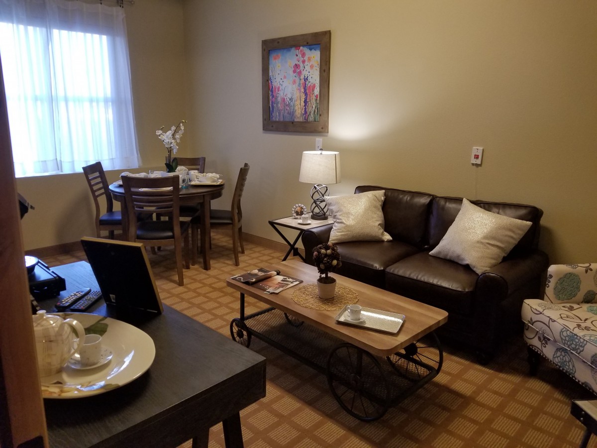 A cozy living room with a sofa, coffee table, and dining area.