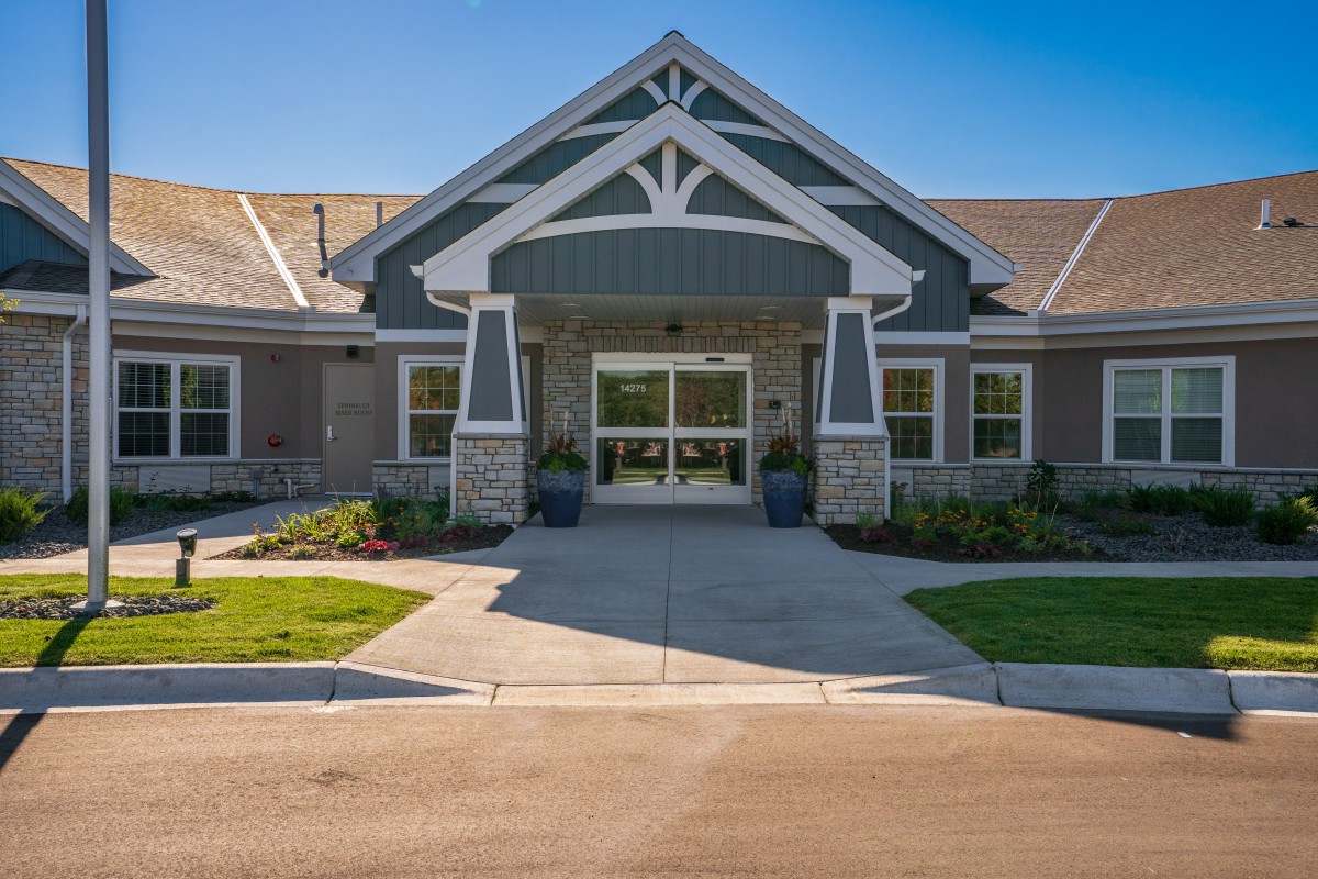 Front view of a modern residential building with a landscaped entrance.