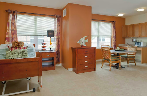 A cozy and well-lit living space featuring wooden furniture and warm orange walls.