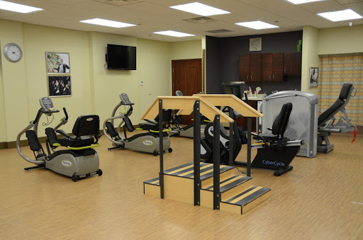 A well-equipped gym featuring various exercise machines and a stair stepper.