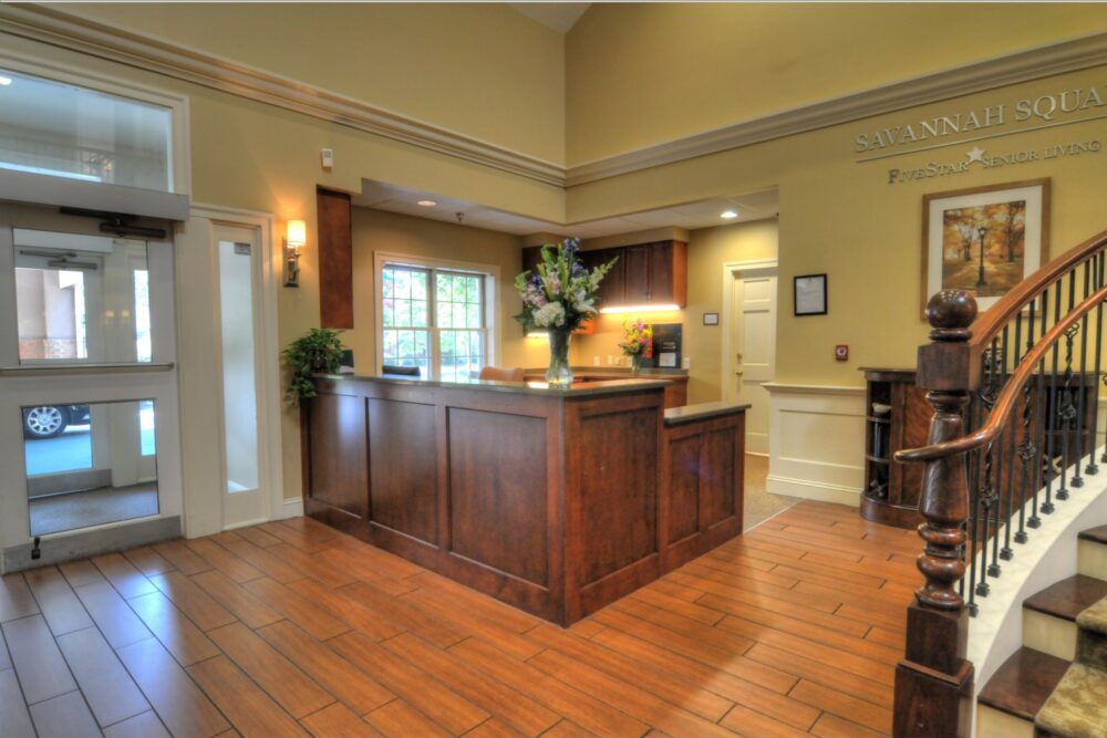 A welcoming reception area with a wooden desk and decorative flowers.