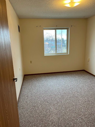 A vacant room featuring a window and neutral-colored walls.