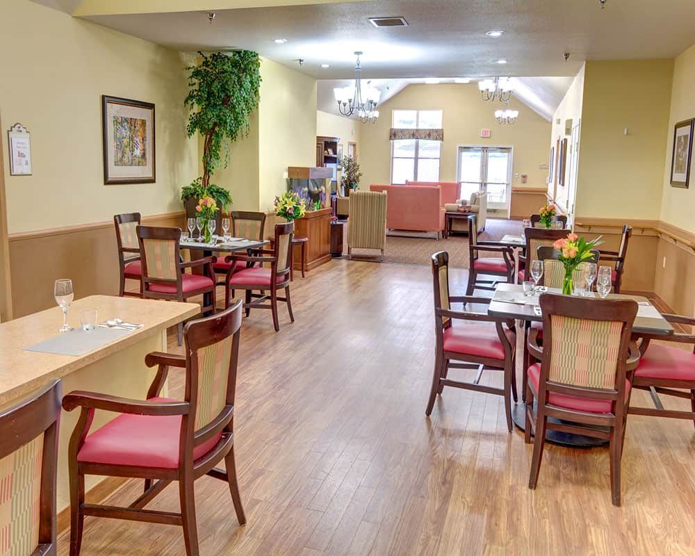 A cozy indoor dining area with wooden floors and neatly arranged tables and chairs.