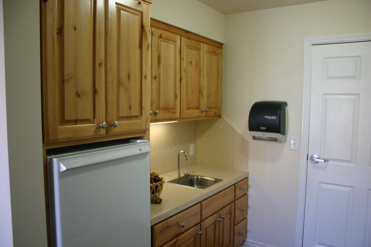 A compact kitchen space with wooden cabinets and a small sink.