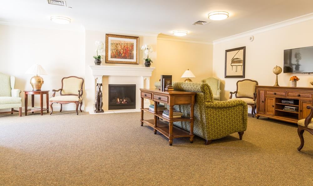 A cozy living room with traditional decor featuring a fireplace and comfortable seating.