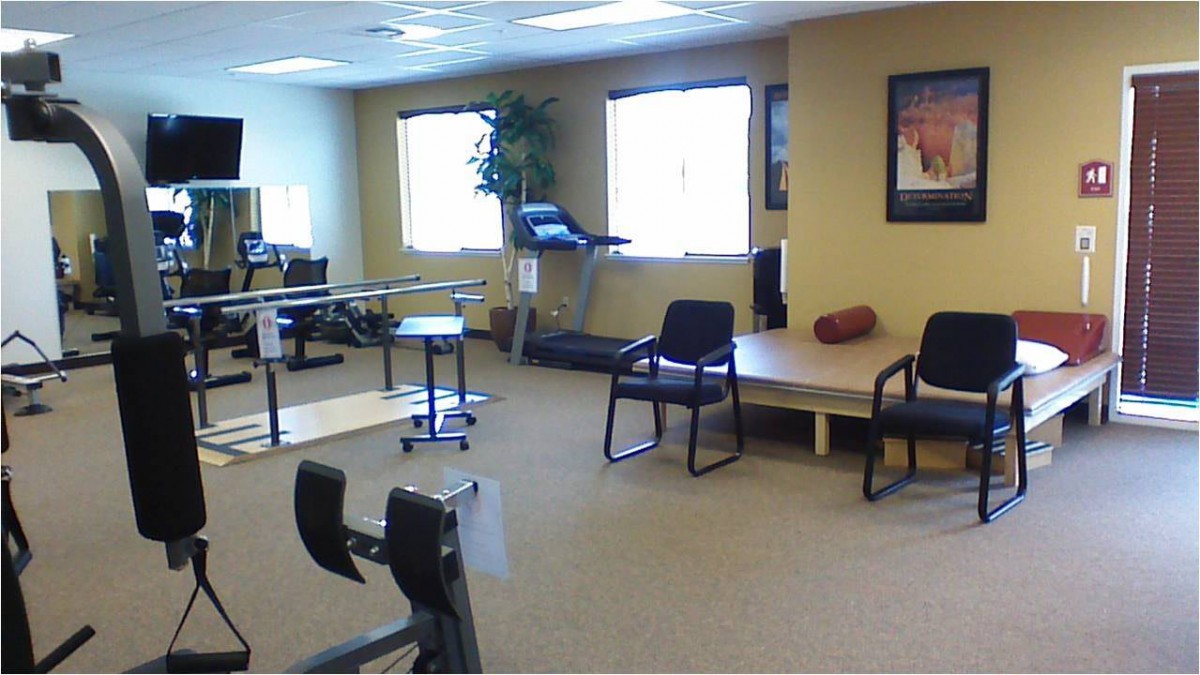 A physical therapy room equipped with exercise machines and rehabilitation tools.