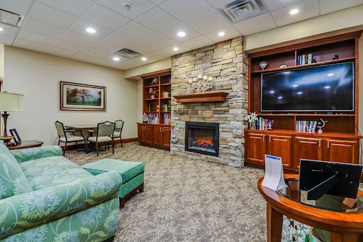 A cozy living room featuring a stone fireplace, comfortable seating, and a welcoming atmosphere.