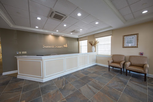 A modern office reception area featuring a sleek front desk and comfortable seating.