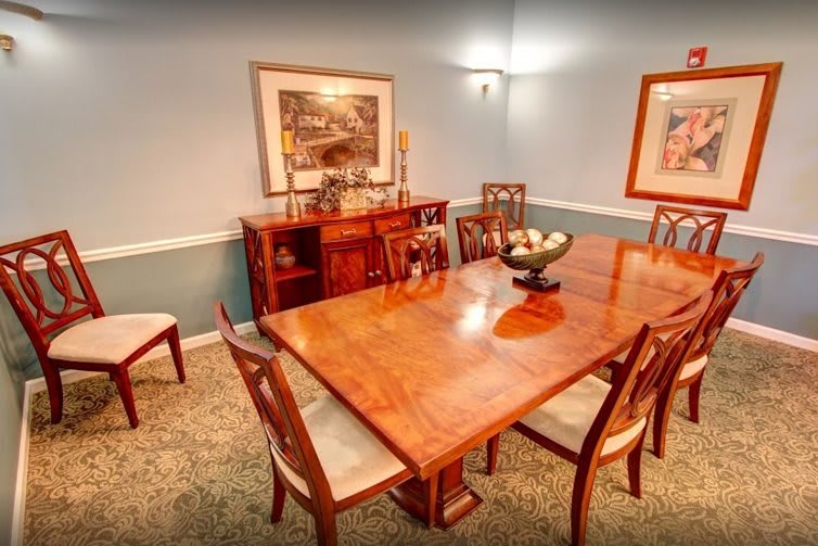 A well-furnished dining room featuring a wooden table, chairs, and decorative artwork on the walls.