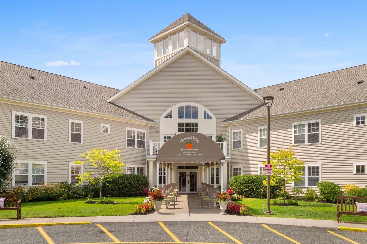 A two-story building with a prominent entrance and well-maintained landscaping on a clear day.