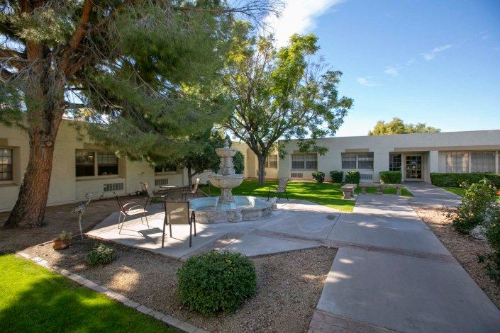 A peaceful courtyard with benches and trees on a sunny day.