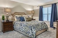 A stylish bedroom with elegant bedding and matching decor.