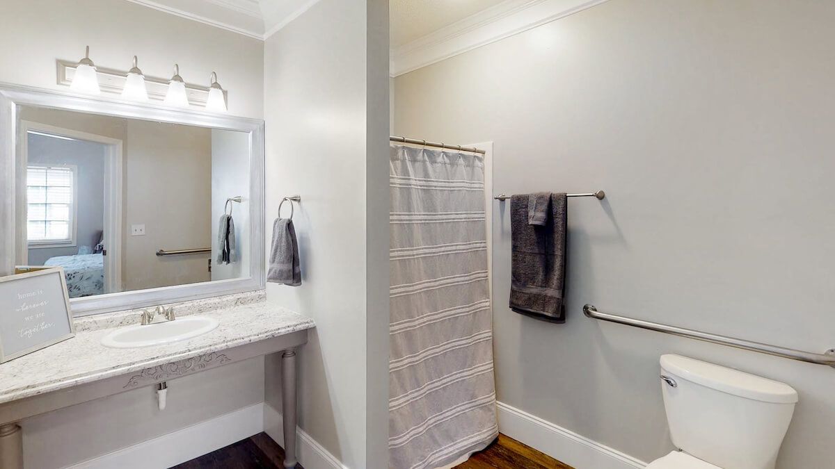 A modern bathroom with a shower, vanity area, and neatly hung towels.