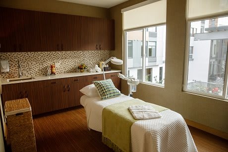 A serene massage room with soft lighting and a comfortable bed, perfect for relaxation.