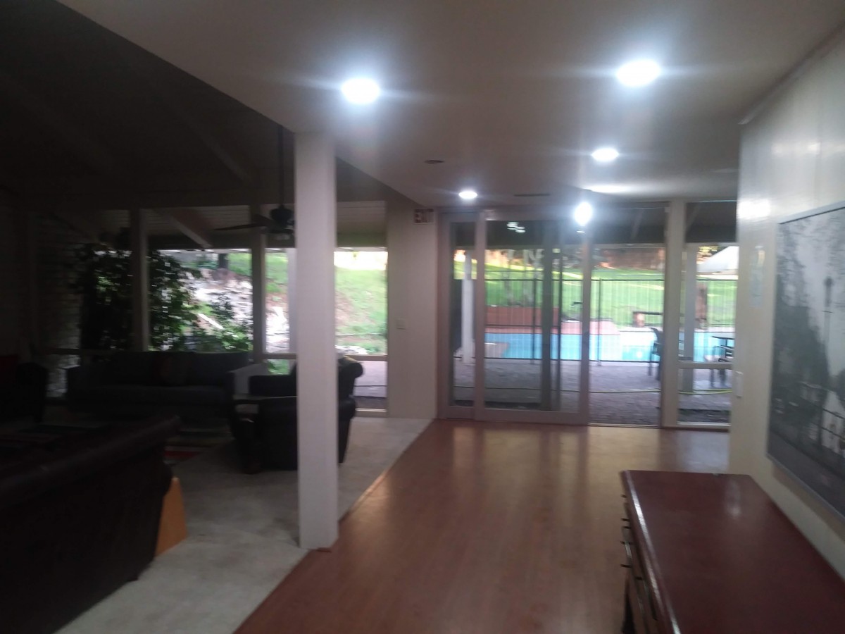 A spacious living room with glass doors offering a view of the pool area.