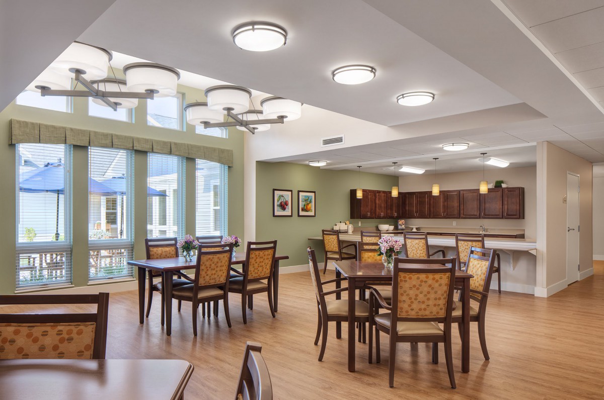 A modern dining area with elegant furniture and ample lighting.