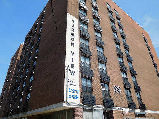 A view of the Hudson View apartment building, showcasing its brick facade and sign.