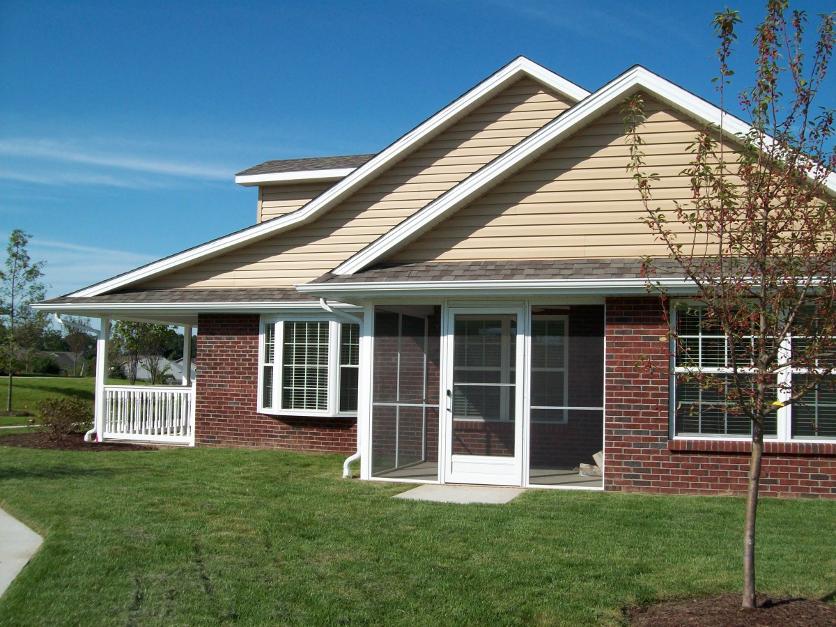 A suburban house with a well-maintained lawn and sliding glass doors.