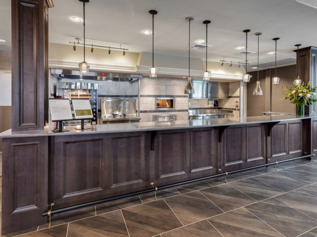 A modern restaurant counter and kitchen with stylish lighting.