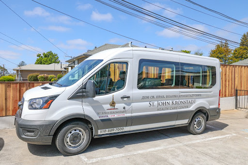 A white shuttle van parked in a sunny area, ready for passengers.