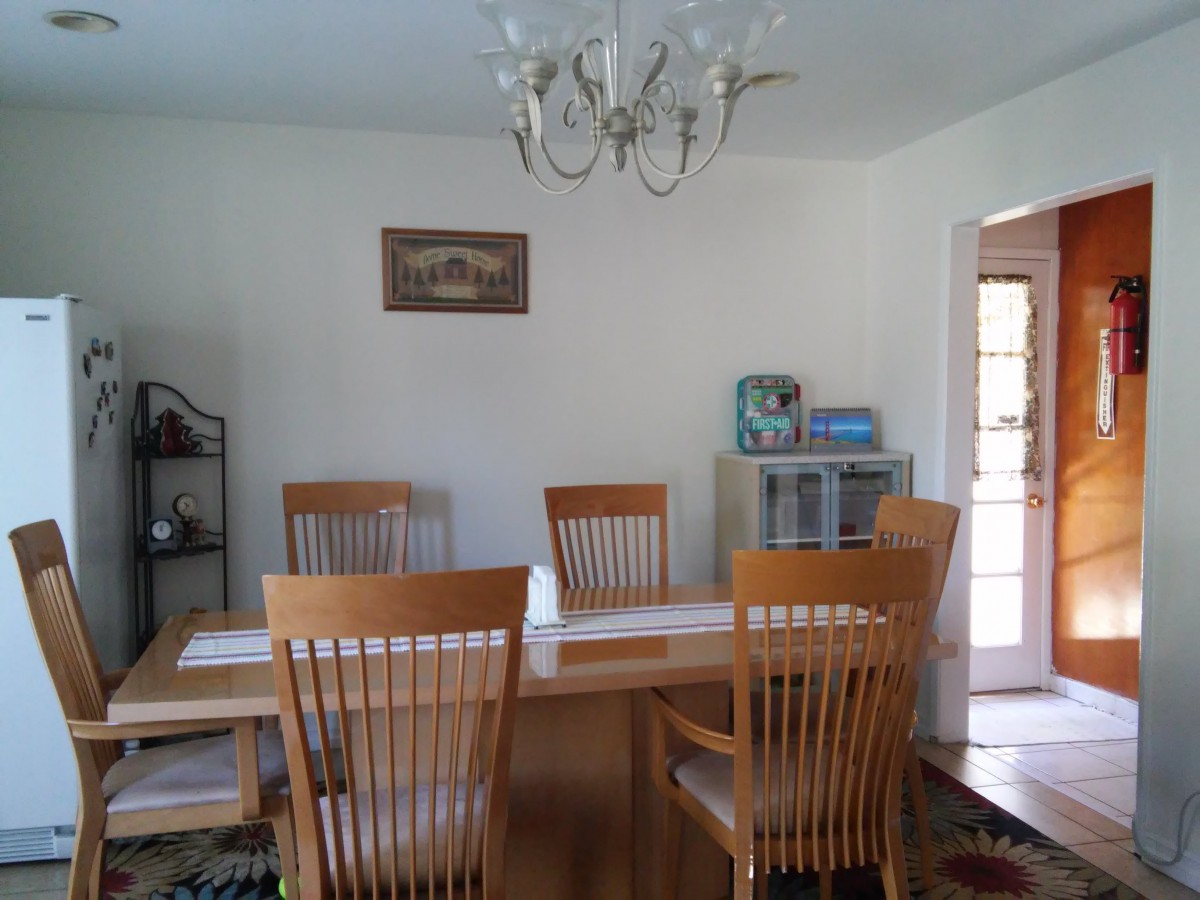 A cozy dining room with wooden furniture and a chandelier.