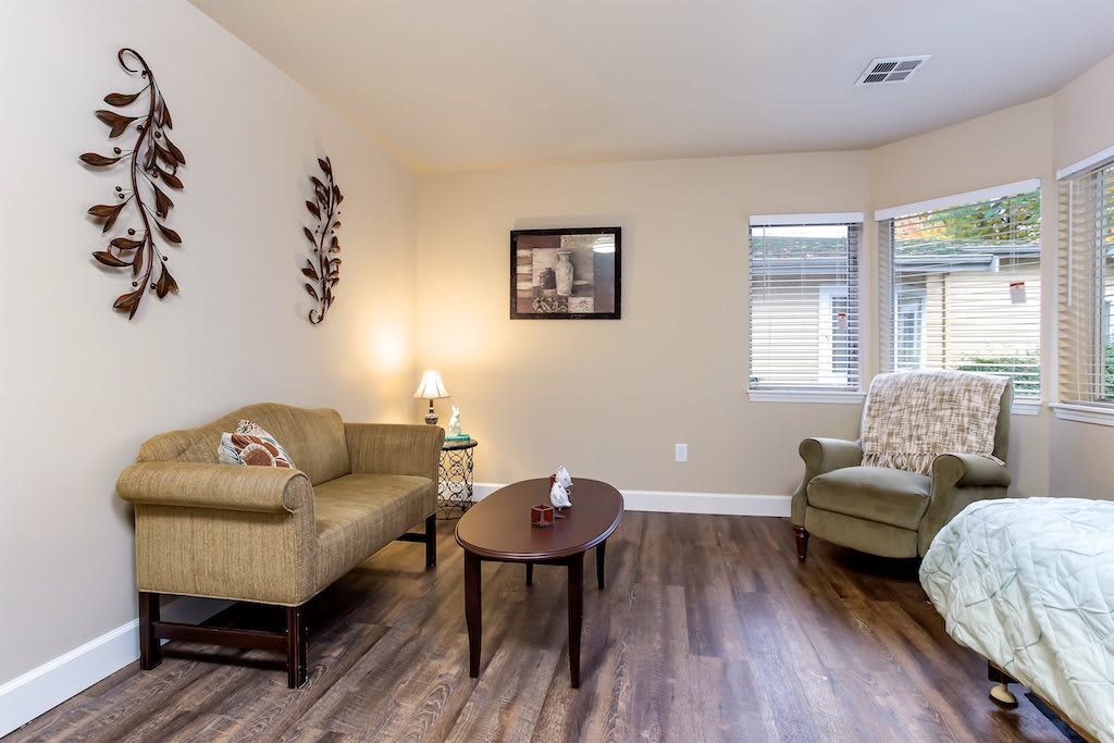A cozy living room with two armchairs, a coffee table, and a lamp, all set on a hardwood floor.