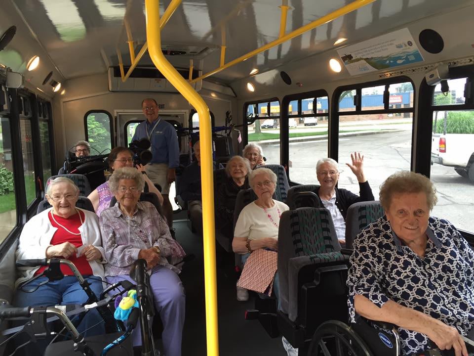 A group of elderly passengers riding a bus together.