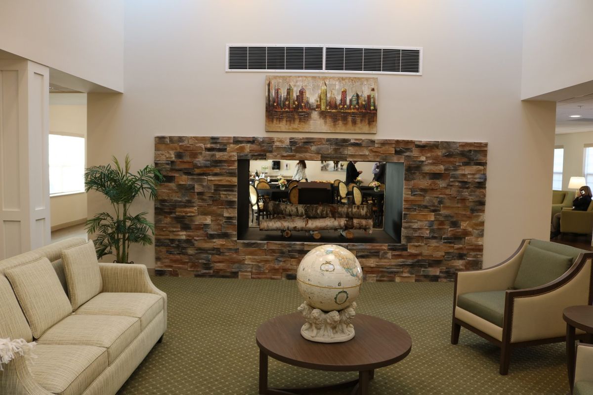 A modern lobby with comfortable seating, a stone accent wall, and decorative art pieces.