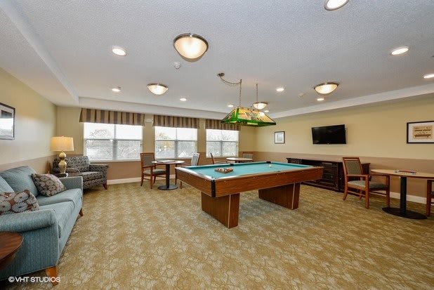 A spacious game room with a pool table and comfortable seating.