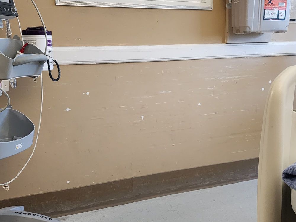 A hospital room wall with medical equipment attached.