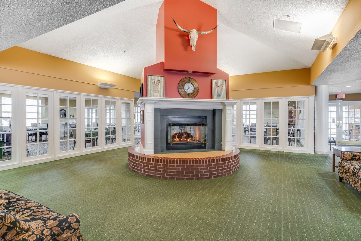 A spacious living room with a central fireplace and skull decoration above the mantel.