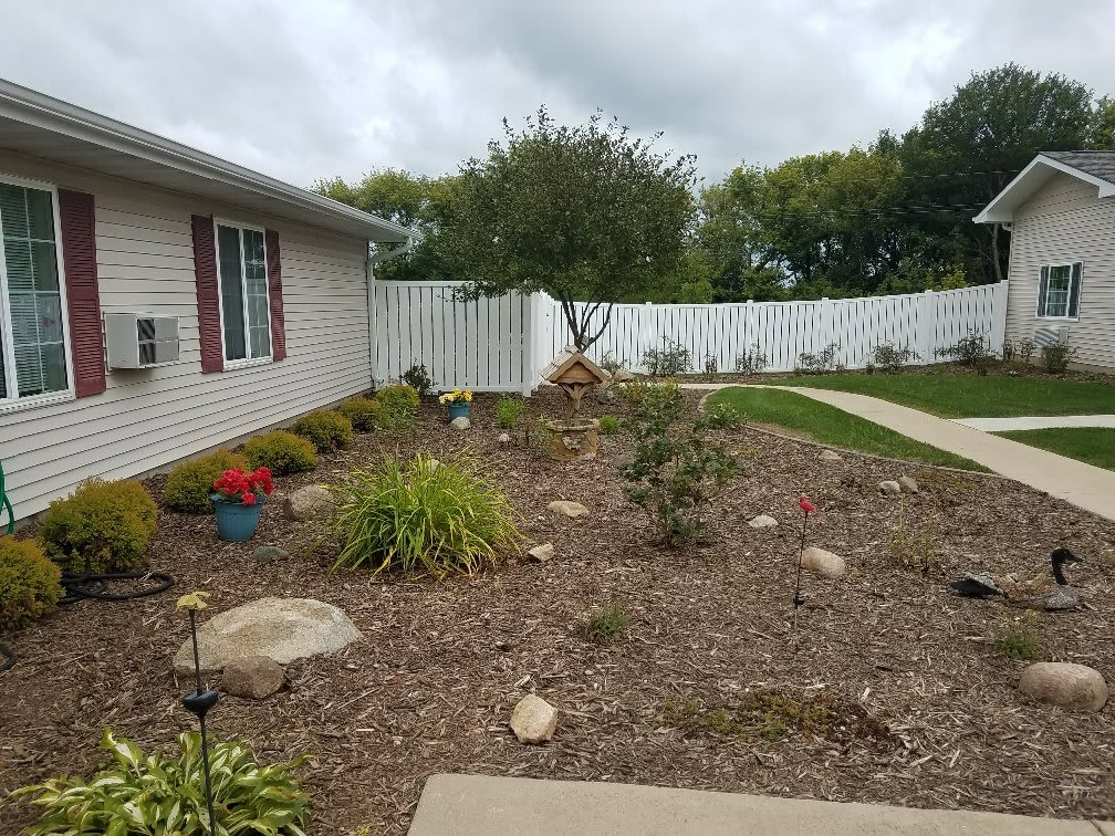 A landscaped garden area with plants and mulch next to a house.