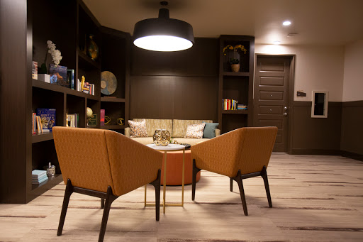 A cozy modern living room setup featuring stylish chairs, a coffee table, and warm lighting.