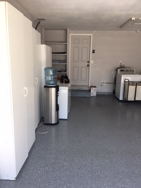 A tidy garage with a water cooler and washing machine.