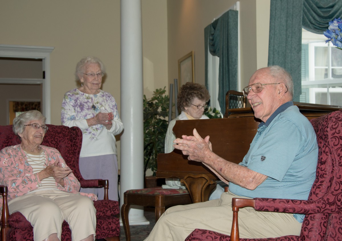 A group of seniors engaging in conversation indoors.