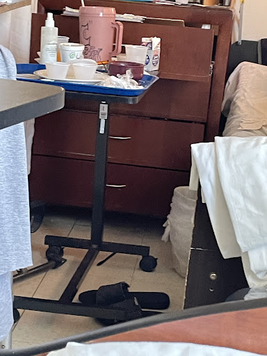 A bedside tray table with medical items in a hospital setting.