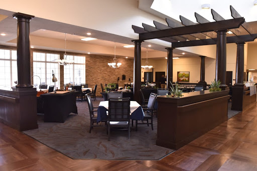 A spacious and inviting dining area in a restaurant featuring modern furniture and warm lighting.